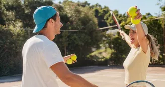 Photo of a loving couple playing tennis together on a tennis court Photo of a loving couple playing tennis together on a tennis court